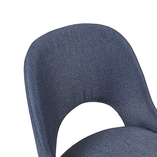 Close-up of the curved back of a navy blue upholstered chair.